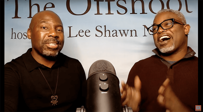 Two Men Talking Into A Mic